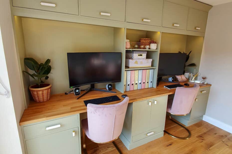 A home office setup with two desks side by side, each with a computer—perfect for avoiding the 5 Mistakes Marketers Make with Pinterest—pink velvet chairs, potted plants, office supplies, and green cupboards above and below a wooden worktop.
