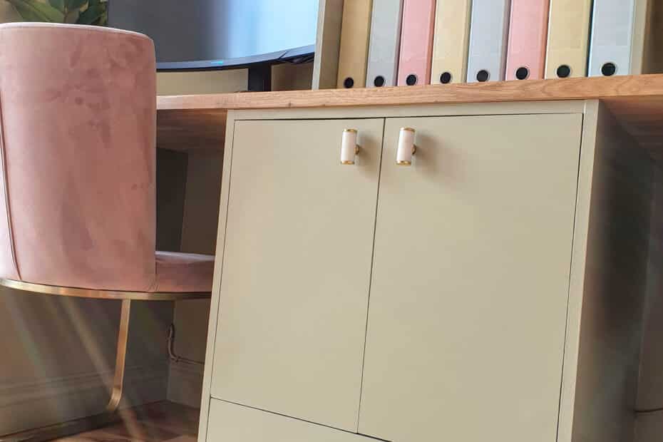A modern home office with a light green desk, gold-handled cupboard, pink velvet chair, and pastel file folders on a shelf—an inspiring space for those looking to make money online without a website as sunlight streams in.